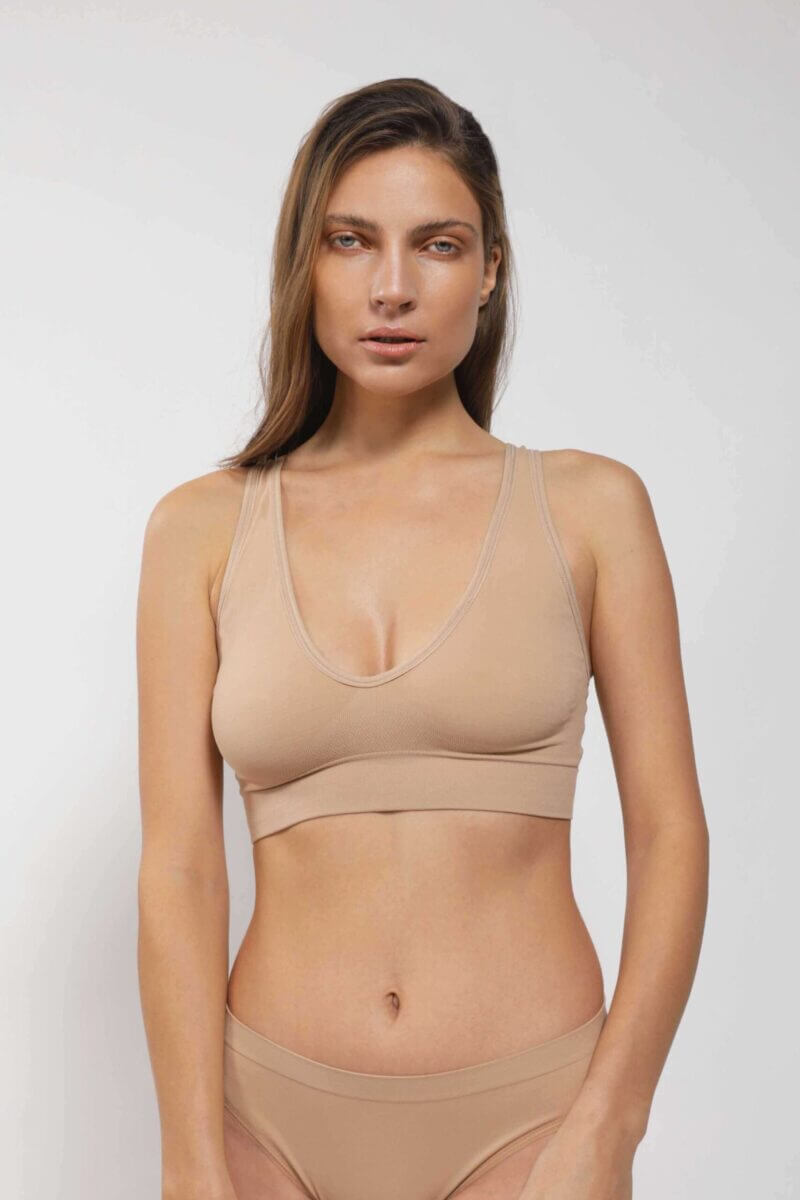 mujer de frente luce brasier escotado con copas tiras gruesas y calzon color beige